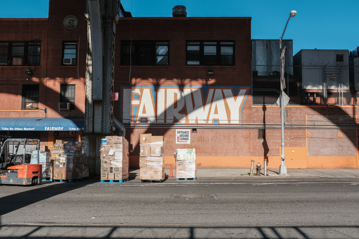 A large painted version of the old logo with outline, spotted underneath the Riverside Drive Viaduct, Harlem, in 2017. The awning at the left shows the version in Dom Bold, with the slogan in yet another bold grotesk, here in title case with straight quotes.