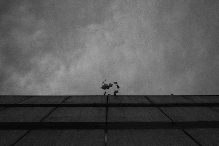 Leaflets are being flung from the top of the building.