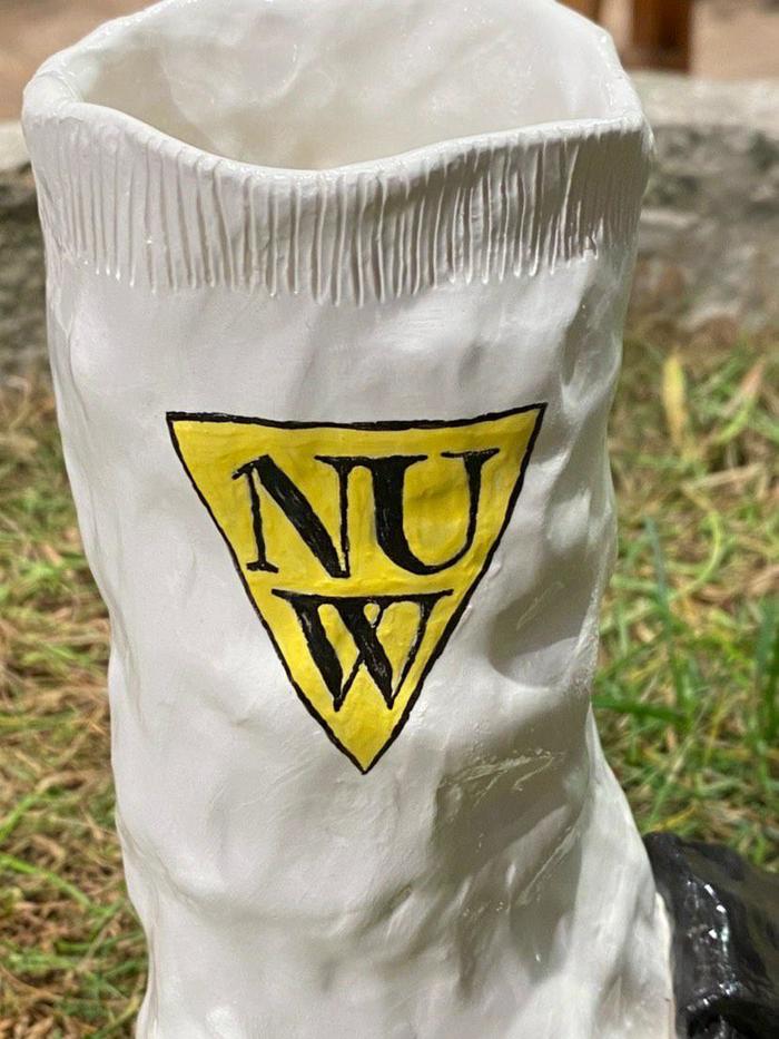 Detail of the ceramic shoe by Lota Lota showing the NUW Store branding.