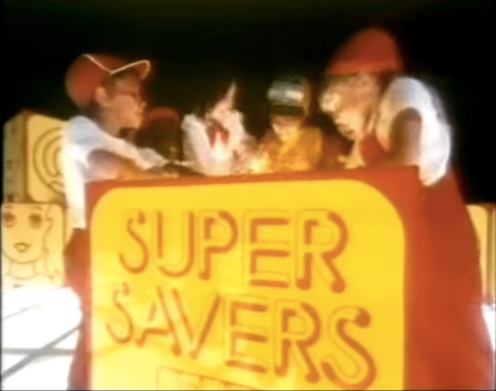 “Supersavers”. Still from a TV commercial, 1983.