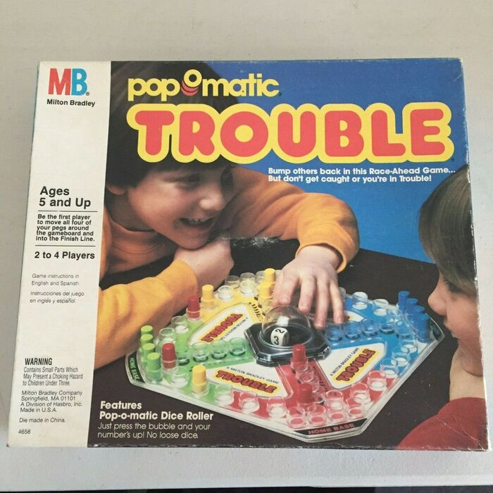 Trouble by Milton Bradley, a division of Hasbro, Inc., 1986, with game instructions in English and Spanish. Smaller texts additionally feature  and .