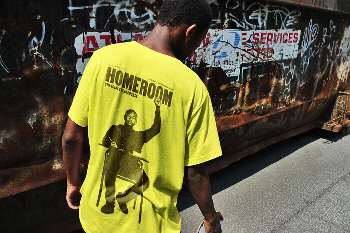 Yellow t-shirt for Homeroom, designed by Mucho, featuring Dwayne Davis with a raised fist.