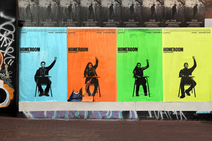 Wild postings of movie posters for Homeroom, designed by Mucho, with yellow, orange, blue, and green backgrounds, featuring multiple students with raised fists.