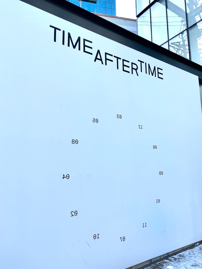 A clockface with jumbled numbers and mirrored type.