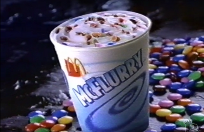 Packaging for McDonald’s McFlurry ice cream, as seen in a 1998 commercial. Type is set in Bodega Sans Black, with a gradient and shadow applied by the designer.