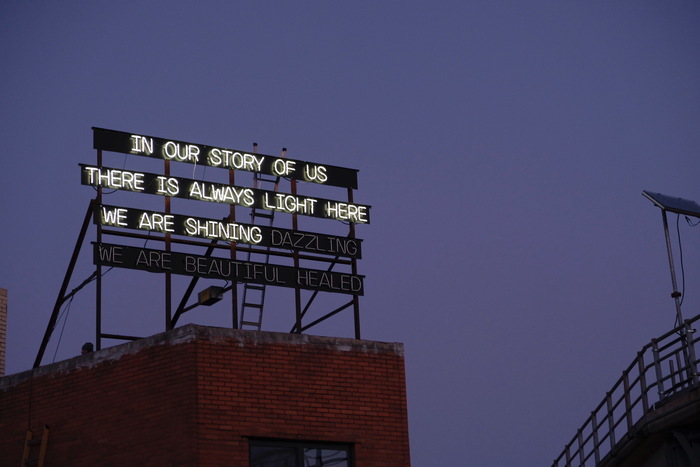 Neon sign featuring a poem written collectively by the community