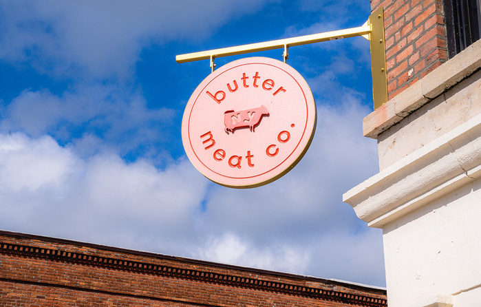 Hanging exterior shop sign at the Butter Meat Co. market in Perry, New York