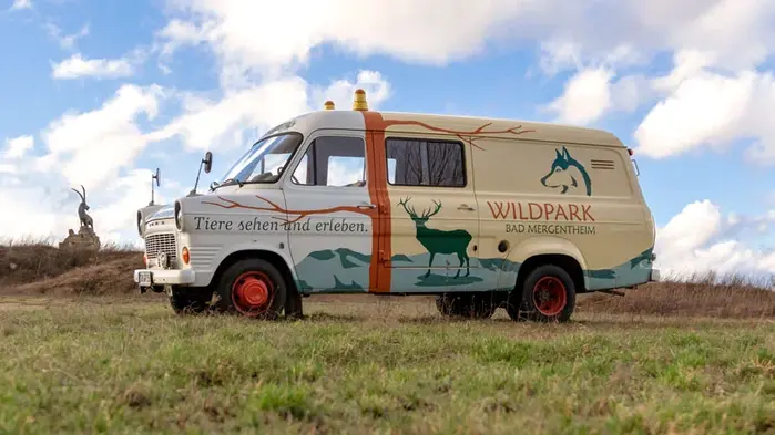 Van featuring the logo in Maiandra and the slogan (“See and experience animals”) in Agendatype Swash Italic