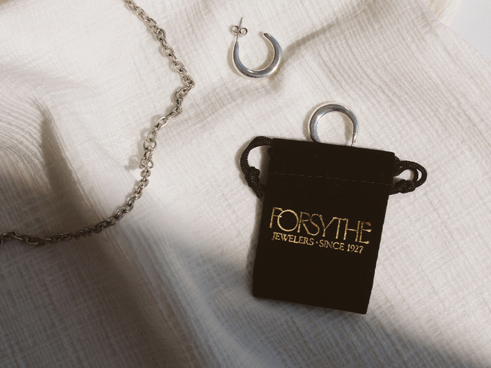 Small chocolate-colored crushed velvet jewelry bag with gold foiled Forsythe Jewelers logo.