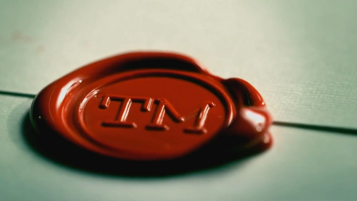 A close-up of one of the show's red wax seals featuring type set in Courier.