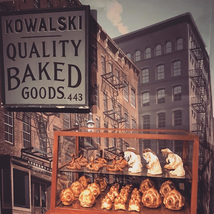 Film props as seen in an exhibit at Warner Bros Studio. Burford is here used with a white shadow to the bottom left. “Quality Baked Goods” appears to be lettering.