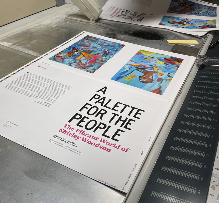 On press with the book. This photo shows the proofing table and press controls. We would proof the color with the pressman and request any adjustments to the sheet, like more magenta or less overall density in a certain section.