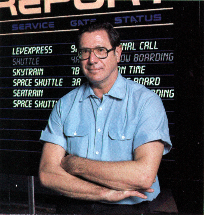 GE Advertising Manager Karl Koss standing in front of the Futureport departures board, as seen in a 1983 promotional booklet produced by General Electric to promote Horizons