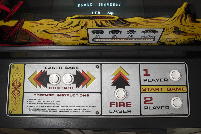 On Midway’s arcade machine, the text on the control panel is set in what appears to be Eurostile. The 1 seen here is likely custom.