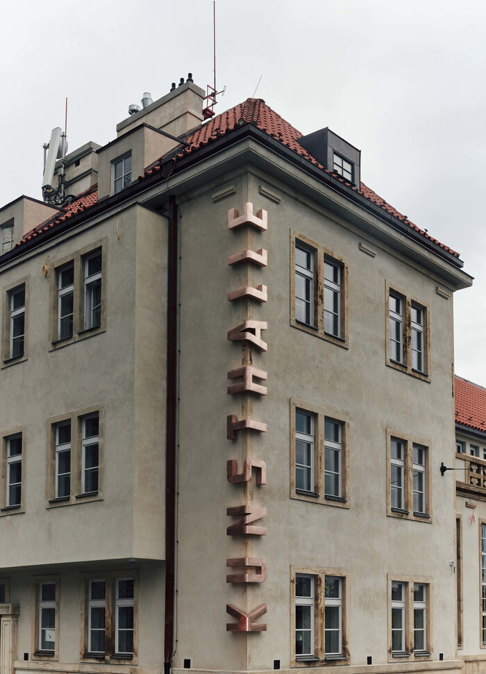 The name is shown in metal letters that are bent around the corner of the building.