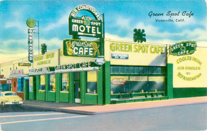 Later, the original sign was moved around the corner and replaced with a more elaborate sign referencing the dude ranches of the area. This postcard clarifies the Green Spot logo found in multiple places on the building, and at the center of the Hobo sign: a splat of green.