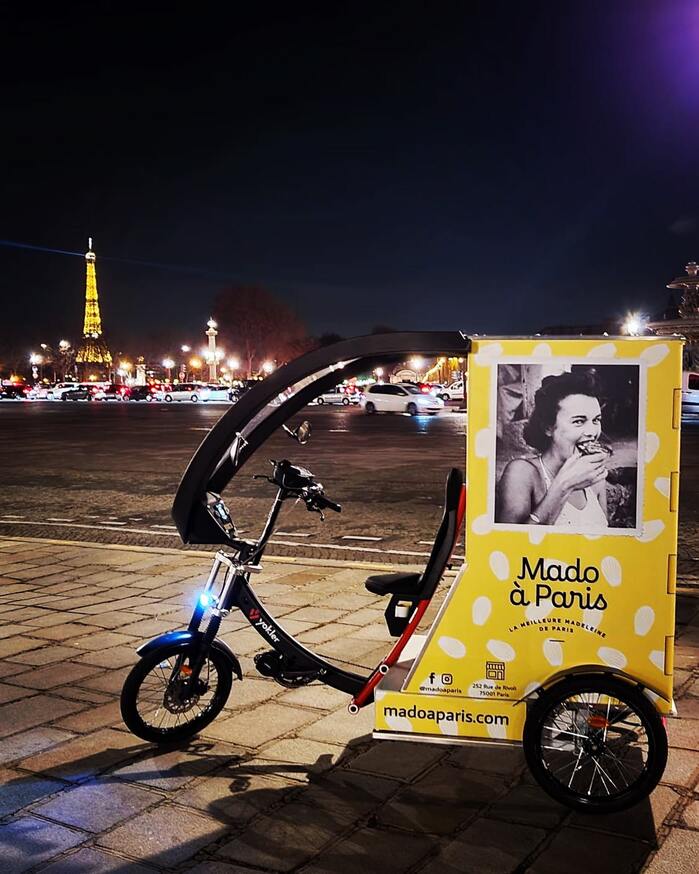 Mado &agrave; Paris tricycle with the illuminated Eiffel Tower in the background