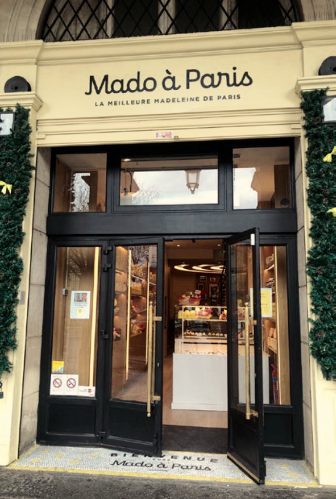 The logo above the entrance and on the floor of the restaurant-boutique at 252 Rue de Rivoli