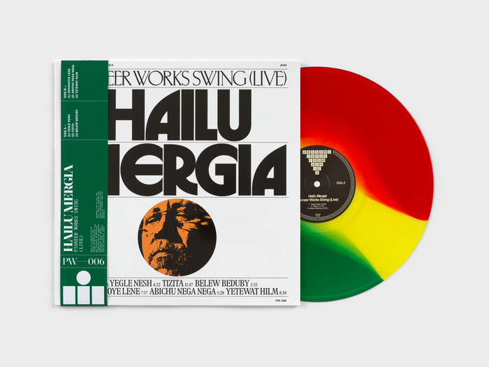 The green banderole shows text in  Bold with . The track names appear to be in , and the small print in  or similar.