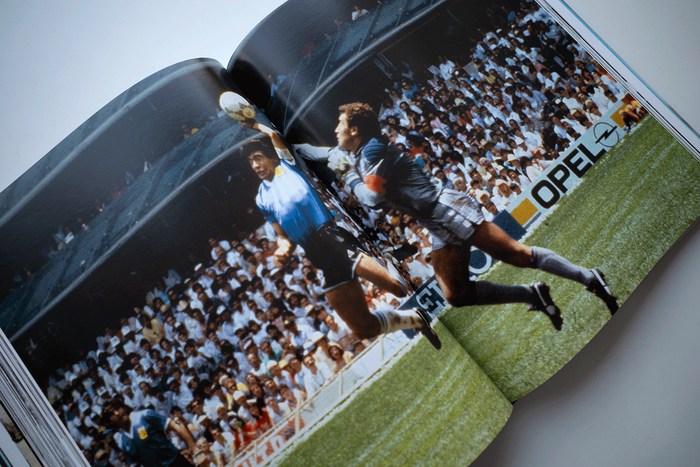 This full-page photograph captures one of the most iconic and controversial moments in football history.