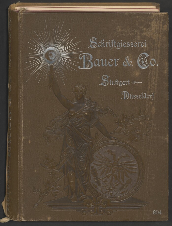 The cover depicts Germania holding a torch in her right hand and a shield with a double-headed eagle in her left. The silver text uses  with its decorated capitals.