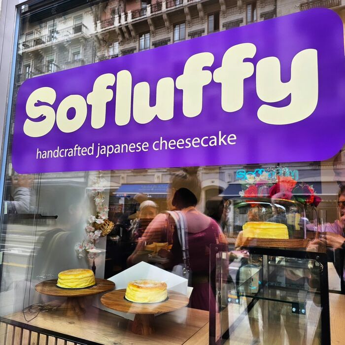 Hard to miss: the purple sign on the shop window with the big wordmark in Omnes. The line below uses .