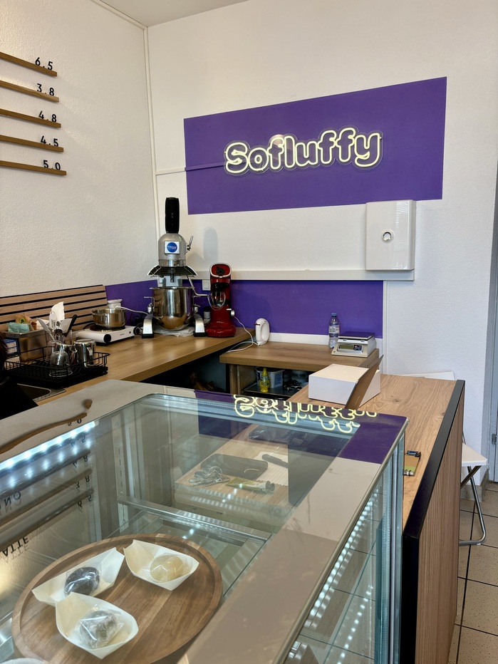 The illuminated sign behind the counter presents an outlined variant of the wordmark.