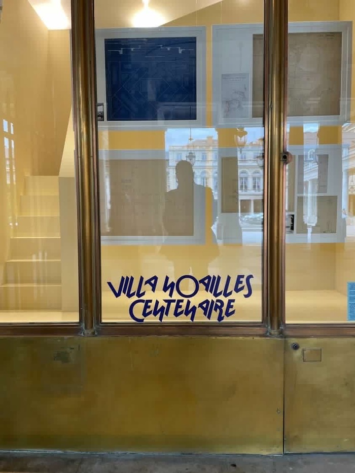 The wordmark for the centenary on a window of the arts center