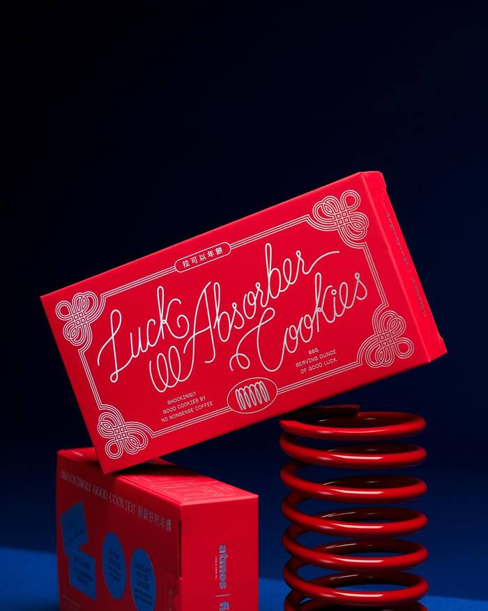 The monolinear script used for “Luck Absorber Cookies” appears to be custom lettering.