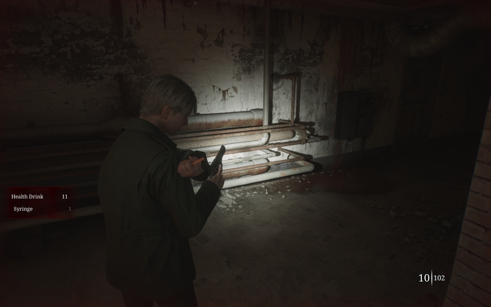 Game HUD. James is seen horrifyingly using a dirty syringe to heal himself, with the health items shown to the left and ammo counter to the right