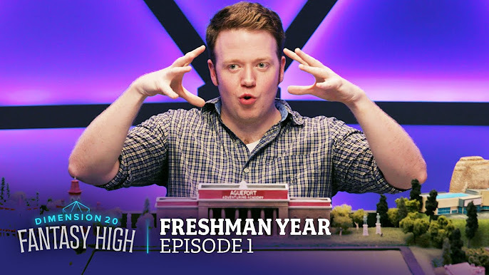 Thumbnail for the YouTube upload of Episode 1 of Fantasy High Season 1. Pictured is Brennan Lee Mulligan, with the text below reading “FRESHMAN YEAR” in Fairplex and “EPISODE 1” in Lev Serif