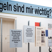 <cite>Demokratie, heast!</cite>