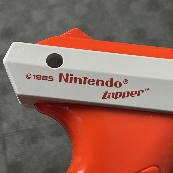 The Nintendo Zapper is a light gun that was launched on October 18, 1985. The orange variant shown here followed in 1988. It uses&nbsp; for “Zapper”.