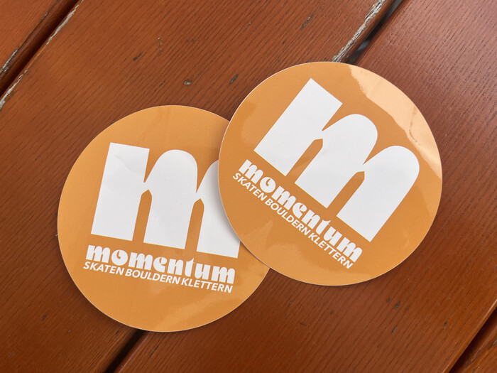Stickers handed to us as first time clients, with a big Motter Ombra m, white on orange.
