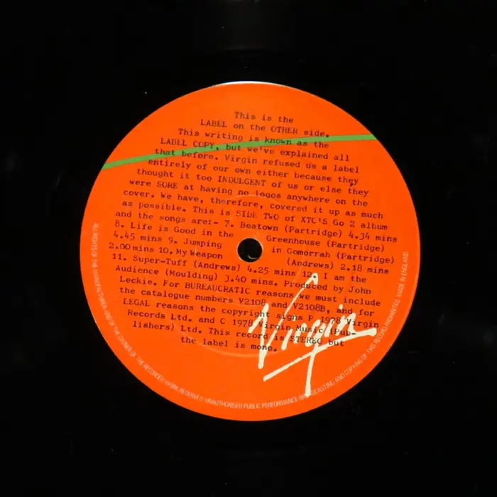 The second side of the vinyl label. The text here reads:


This is the LABEL on the OTHER side. This writing is known as the LABEL COPY, but we've explained all that before. Virgin refused us a label entirely of our own either because they thought it too INDULGENT of us or else they were SORE at having no logos anywhere on the cover. We have, therefore, covered it up as much as possible.