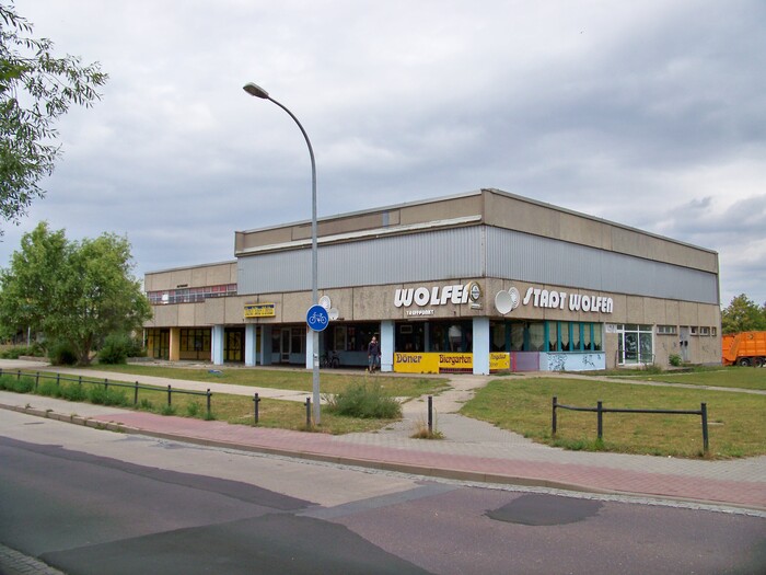 In July 2009, the building housed a döner joint (with signs in ). The “Treffpunkt Wolfen” sign had white letters.