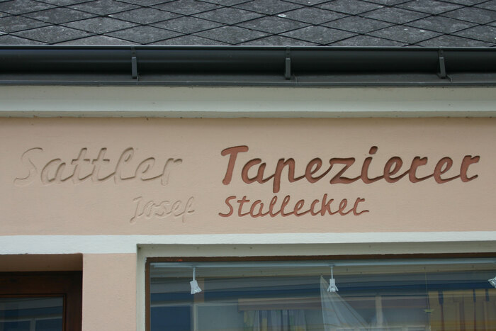Metal Signal came with two forms for the lowercase r, but without one that omits the exit stroke (FDI Lettograph automatically inserts such a contextual alternate, see above). The sign painter invented an optimized terminal form for “Sattler”, but didn’t use it for “Tapezierer”. In “Stallecker”, they made up for it with an impromptu swash.