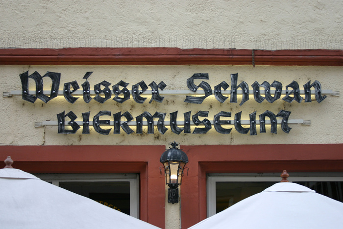 The sign on the façade uses custom-made letterforms. They are still based on a typeface, though, albeit loosely: it’s a bolder rendition of another design by , namely . See its glyph set for comparison.

&nbsp;

“Weisser” is here spelled with a double s instead of an eszett (ß). This isn’t quite according to the rules, but perfectly readable. Blackletter aficionados will notice another, more serious error. Can you spot it? (And no, I’m not talking about the use of all caps for “BIERMUSEUM”).