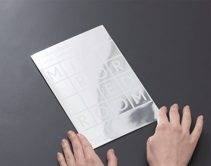 Takeaway exhibition guide for Looking Back: Lucas Samaras’s Mirrored Room printed on mirrored paper