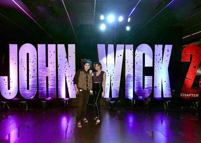 Members of the public pose on front of giant 3D type in a Bangkok cinema