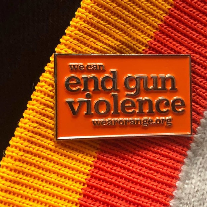 Metal pin with raised letters. In the “end gun violence” slogan, Jubilat is used with its alternate single-storey g.