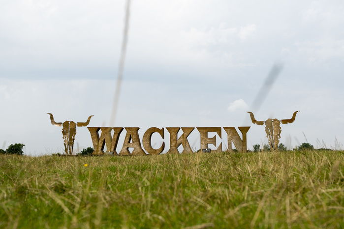 Framed with skulls,&nbsp;the giant Wacken logo made of steel welcomes the visitors at the&nbsp;festival venue.
And yes, of course the kerning is wack.