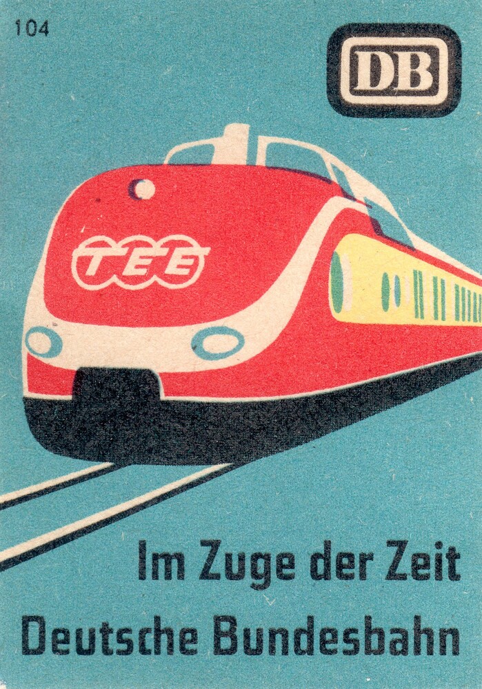 “Im Zuge der Zeit” means both “in the course of time”, but also “in the train of today”. The depicted trainset was manufactured in 1957. The Trans Europ Express&nbsp;network was set up in the same year.