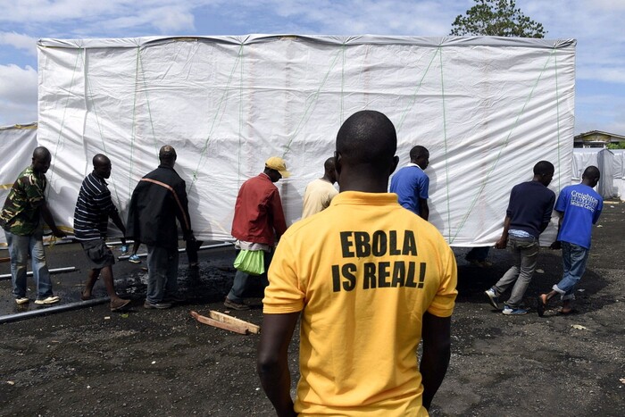 A man looks on as workers set up a new treatment centre as part of the fight against the deadly ebola virus in Monrovia, Liberia.