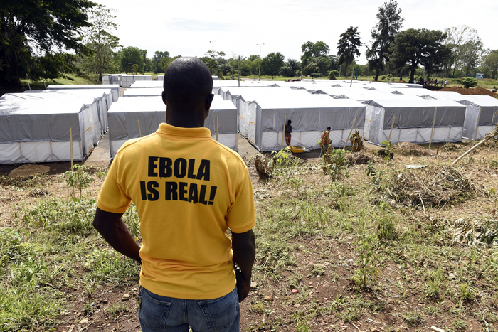 A man stands above a new Ebola treatment center in Monrovia, Liberia. Health workers in Liberia, the hardest-hit nation, have turned people away from treatment units because of shortages of beds and staff.