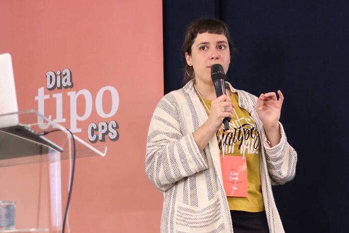 Cyla Costa and a conference identity banner on stage