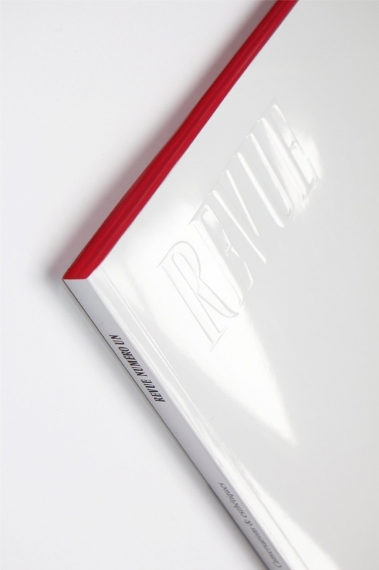 The physical magazine cover features only the embossed “REVUE” logo on white. Both issues’ reading edges are colored.