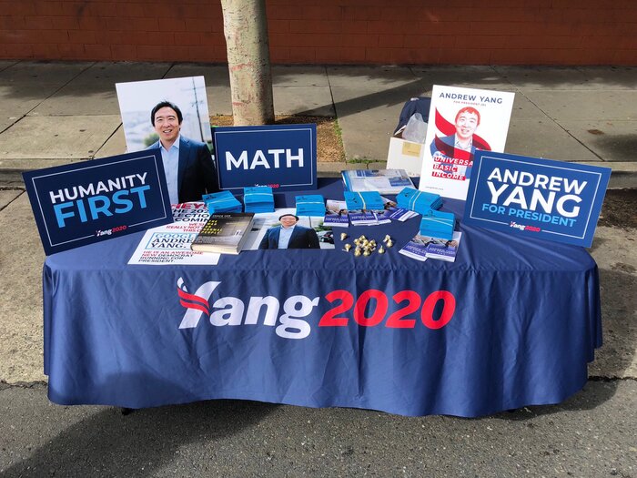 The logo in Halyard Display as seen on a table with campaign materials. The sans-serif caps used for “Humanity First” etc. are from Montserrat.