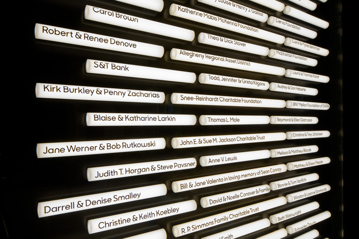 The donor wall features donor names on tubes, framed in a box.